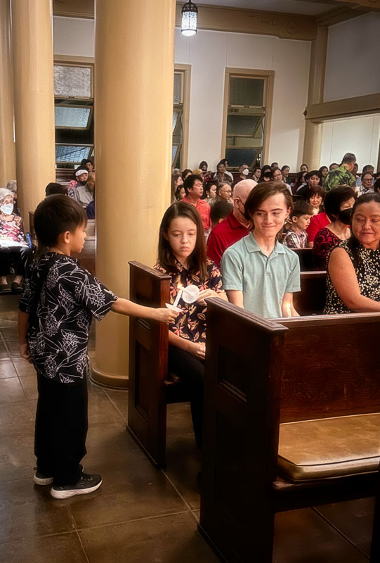 Child with candle at Christmas Eve service